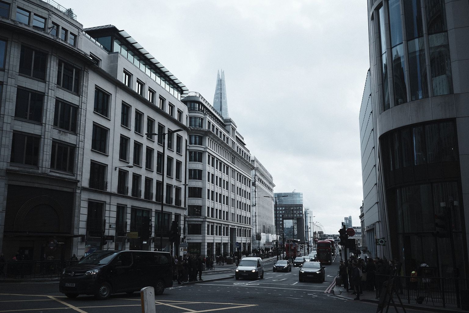 Street scene with busy traffic and pedestrians, surrounded by modern buildings
