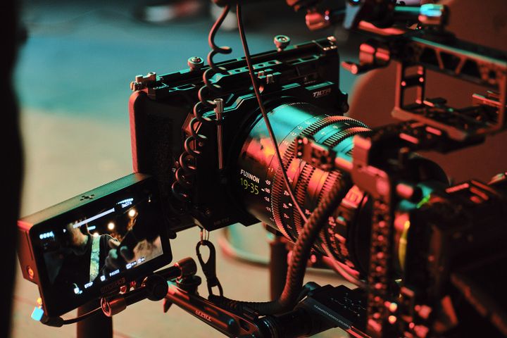 Professional video camera setup with a large lens and monitor